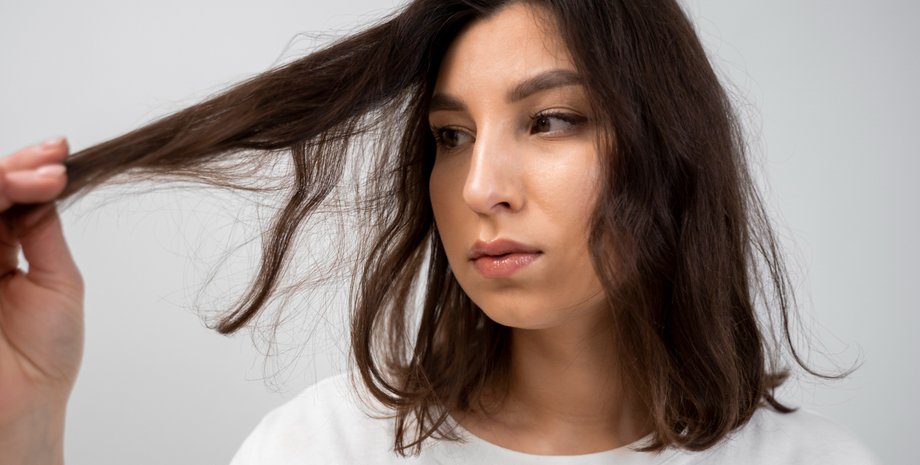 Девушка держит прядку волос