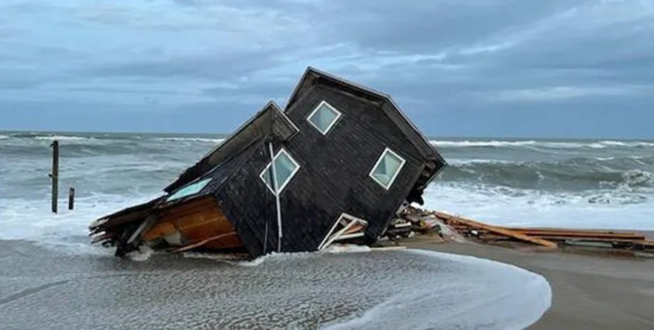 Разрушенный дом на побережье Внешних отмелей в Северной Каролине, частично погруженный в океан