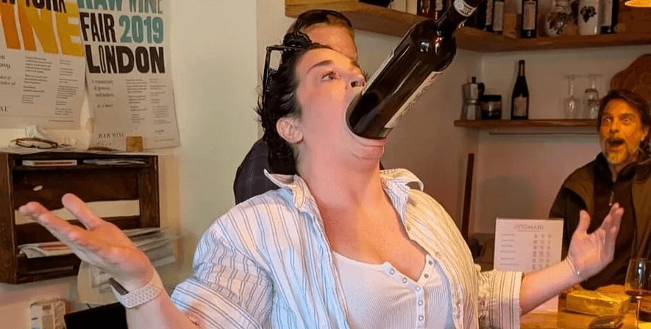 Женщина с самым широким ртом, женщина с необычной внешностью, частично питон, поразила зрителей, рекорд Книги Гиннесса, бутылка вина