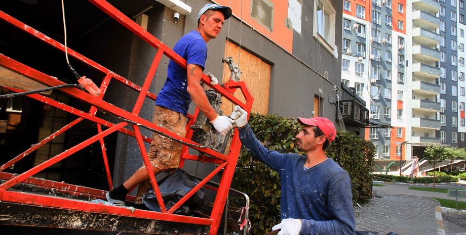 Будівельники тримають металеву конструкцію