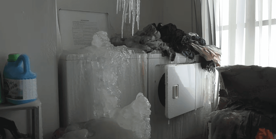 Стиральные машины и мебель, покрытые толстым слоем льда в замерзшей квартире в Квебеке после прорыва труб зимой