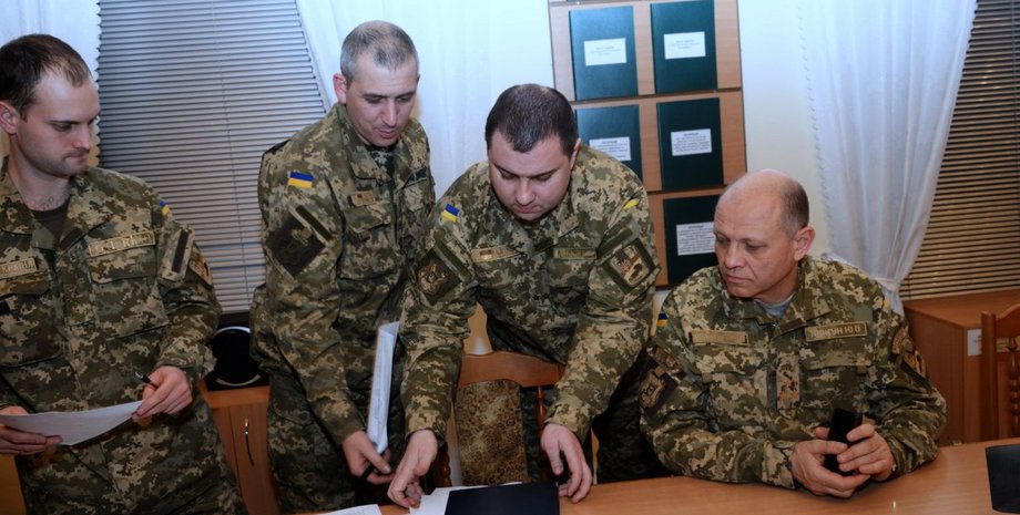 Работники ТЦК перебирают бумаги во время мобилизации в Украине