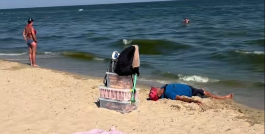 Усталый торговец из Затоки прилег на пляже и задремал во время работы
