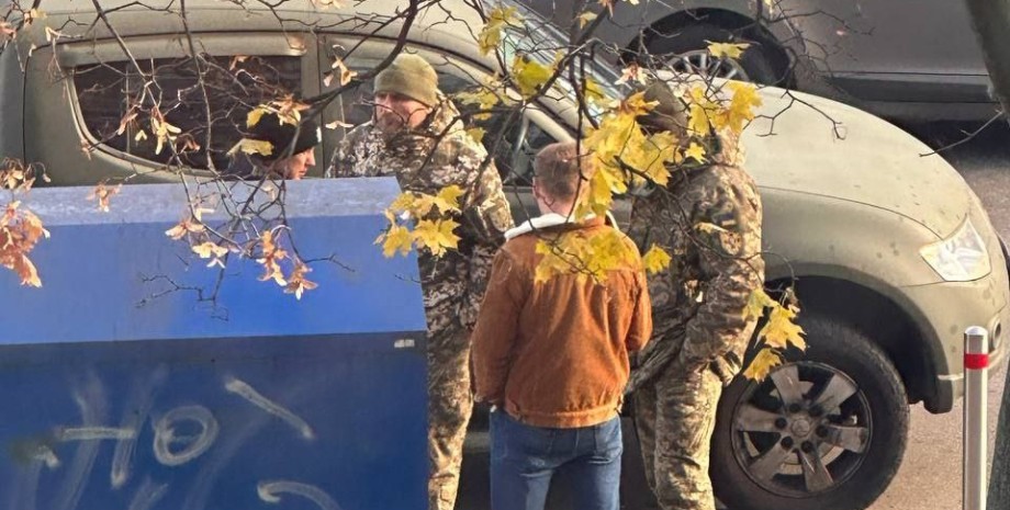 Сотрудники территориального центра комплектования и соцподдержки проверяют документы на улице ТЦК, проверка документов