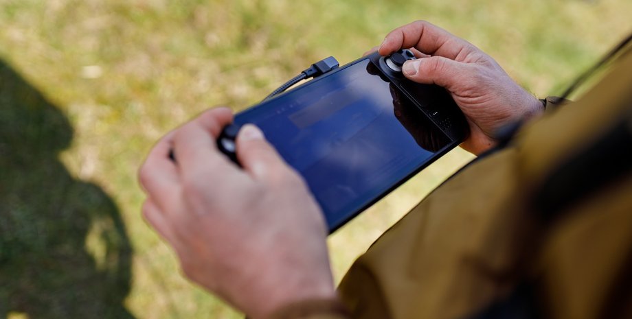 Военный управляет наземным дроном на испытаниях