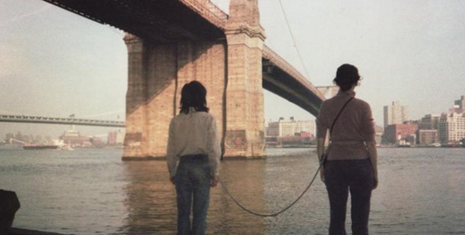 Линда Монтано и Течинг Се стоят на набережной под мостом, связанные веревкой в рамках необычного эксперимента