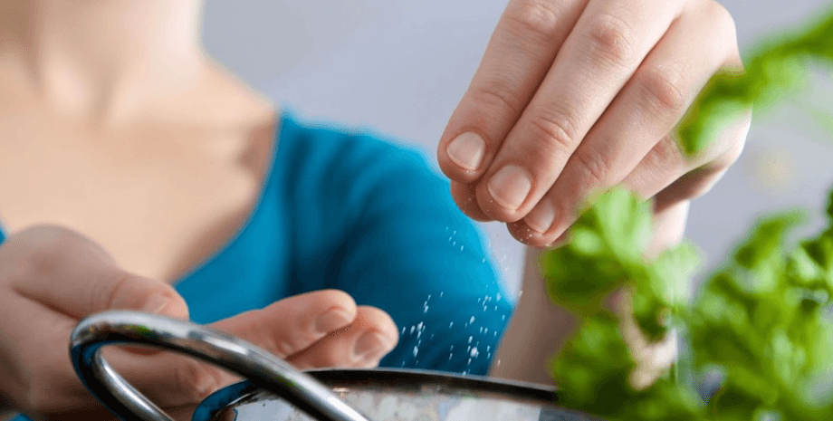 Женщина солит блюдо