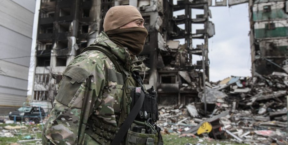 Украинский военный , разрушенный дом.