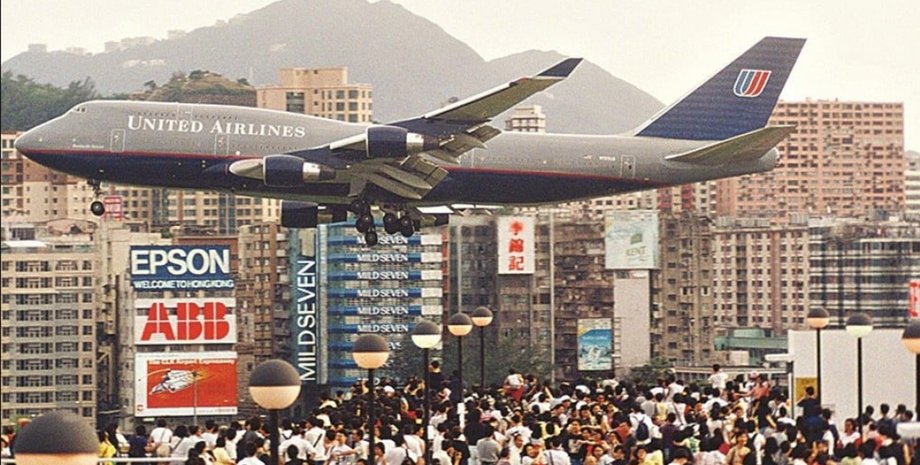 Лайнер United Airlines пролетает чрезвычайно низко над толпой людей перед посадкой в опасном аэропорту Кай Так в Гонконге