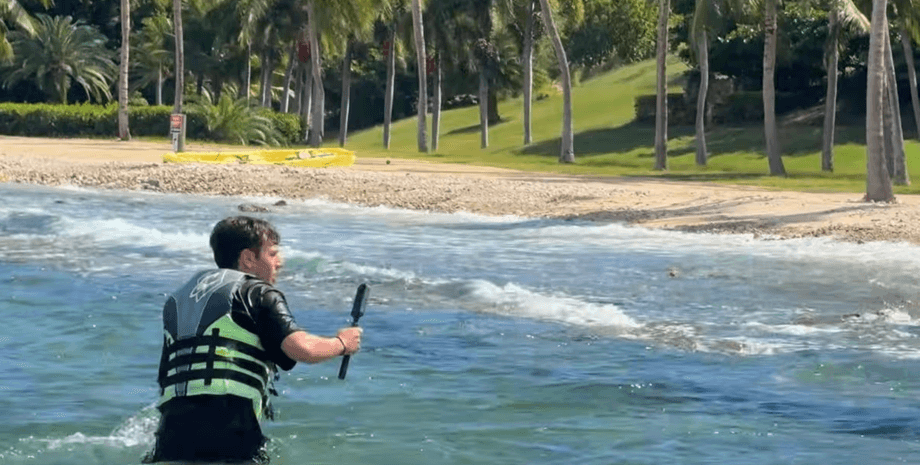 Ютубер Ніко Грігг у рятувальному жилеті знімає берег колишнього острова Епштейна під час поїздки на гідроциклі