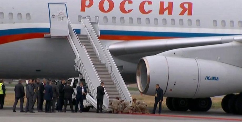 Солдаты на Аляске стелят ковер возле самолета