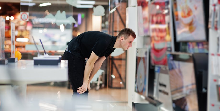 Какой телевизор выбрать Мужчина выбирает телевизор в магазине