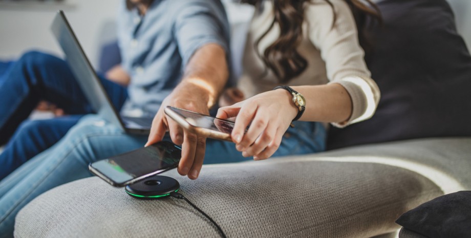 мужчина и женщина заряжают смартфоны с помощью беспроводной зарядки беспроводная зарядка