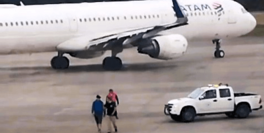 Пассажир выбежал перед самолетом, взлетная полоса, мужчина хотел остановить самолет, опоздал на самолет, пропустил рейс