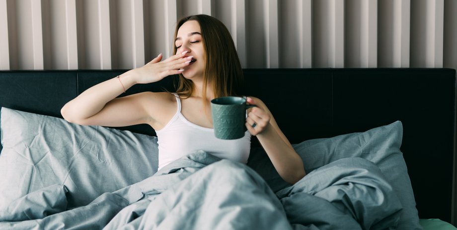 Девушка в постели с чашкой чая