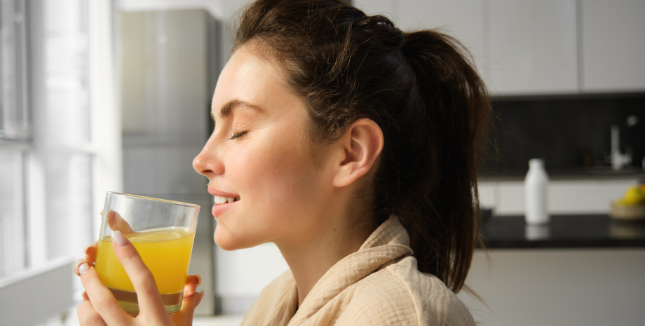 Девушка пьет апельсиновый сок