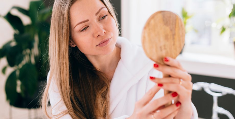 Дівчина дивиться в дзеркало