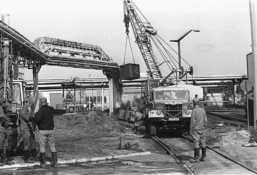 Автокран на шасси КрАЗ производит сбор ящиков с радиоактивными отходами неподалеку от разрушенного четвертого энергоблока Чернобыльской АЭС