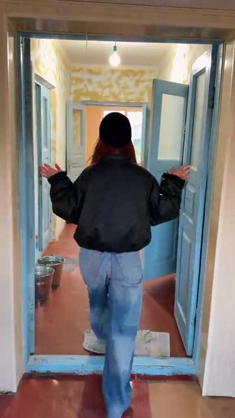 Жінка показуєхату в селі