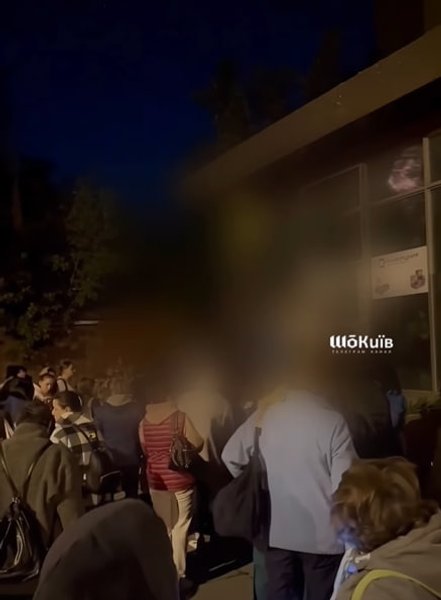 люди стоять біля дверей укриття у Києві 30 липня