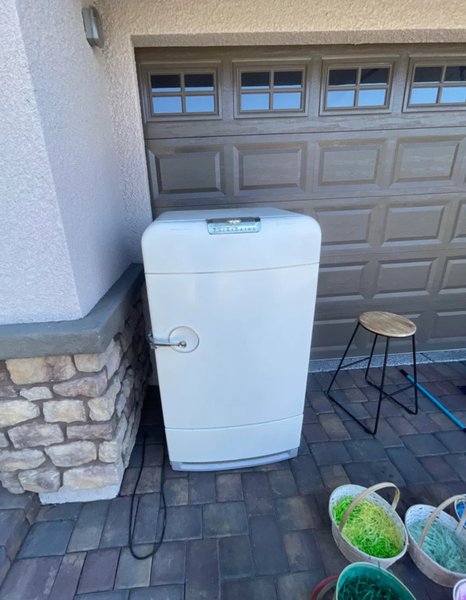 Білий вінтажний холодильник середини XX століття біля гаража, куплений на гаражному розпродажі