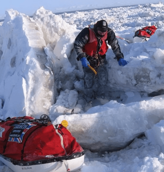 Карл Бушби пробирается через массивные льды в арктических условиях, ведя сани с оборудованием во время своего пешего путешествия