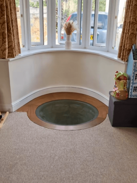 Встроенный в пол гостиной колодец под стеклянной панелью перед окном