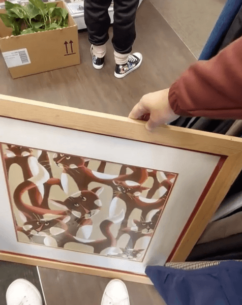 Мужчина держит в руках картину с изображением кошек в деревянной раме, купленную за 20 фунтов