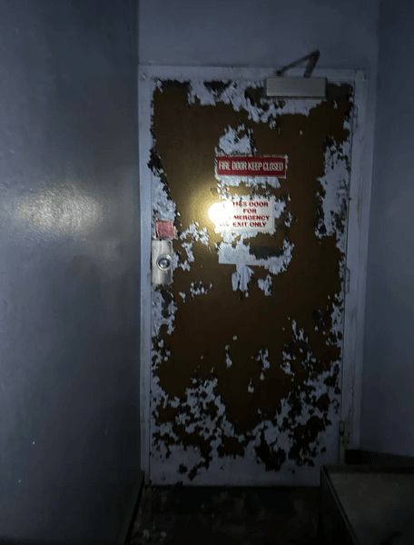 Іржаві аварійні двері в покинутій лікарні, сфотографовані дослідником під час огляду