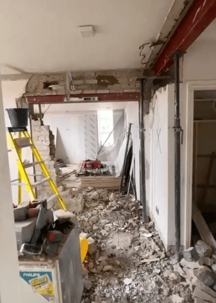 Комната в британской квартире с разрушенными стенами после работы подрядчика