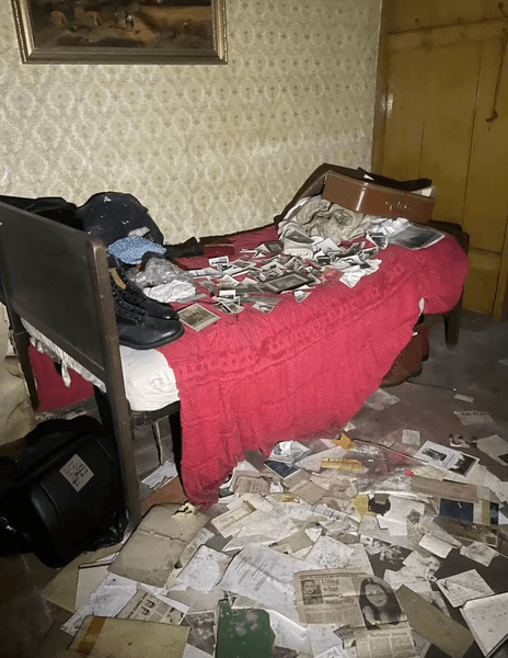 Спальня в старом заброшенном доме с кроватью, бумагами и личными вещами пожилой пары