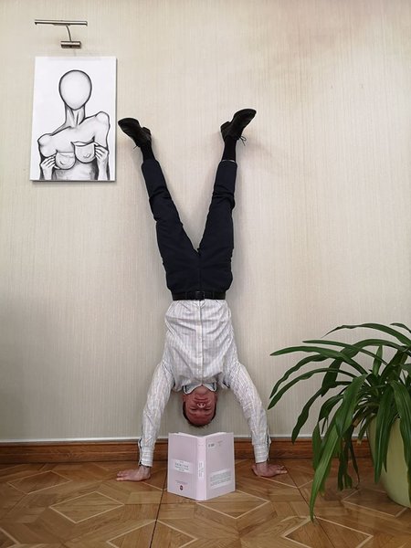 денис малюська, читает книгу, стоя на руках