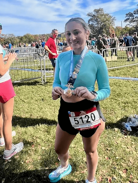 Кэти Веллиос держит медаль после марафона в Вашингтоне