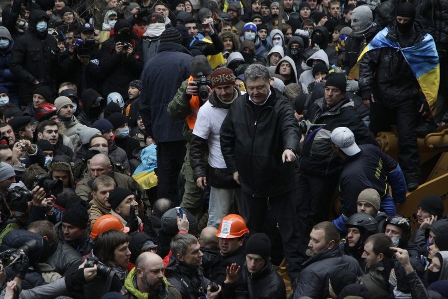 1 декабря 2013 года. Будущий президент Украины Петр Порошенко, стоя на грейдере, призывает не обращать внимания на провокаторов, бросающих камни в милицию. Задержаны и избиты девять человек. Их называют "узниками Банковой".