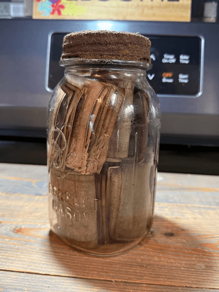 Банка с пачками старых долларов датированных 1930 годом стоит на деревянной поверхности