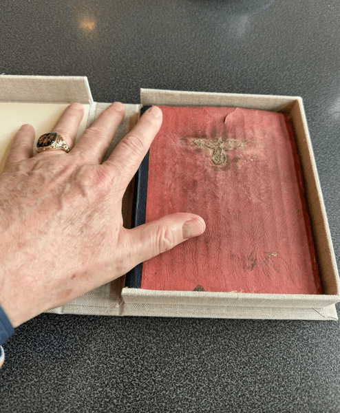 Рукописний щоденник у захисній коробці з нацистською символікою на обкладинці, виявлений на горищі