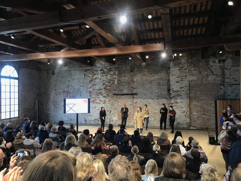 Амфітеатр у будівлі Арсеналу буквально тріщить від охочих бути присутнім на офіційному відкритті павільйону України на бієнале. На сцені — художник Павло Маков, куратори Лизавета Герман, Марія Ланько і Борис Філоненко а також комісар проєкту заступника міністра культури Катерина Чуєва