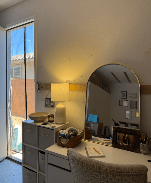 Уютное рабочее место с зеркалом и лампой у окна в квартире, которую отец переоборудовал из гаража для дочери