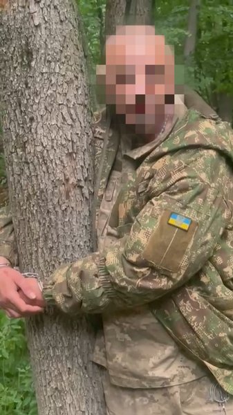 Неизвестный военнослужащий, прикованный наручниками к дереву
