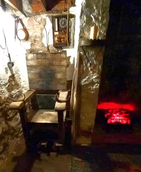 Подвал старинного дома в Великобритании с необычным деревянным стулом с фиксаторами для рук