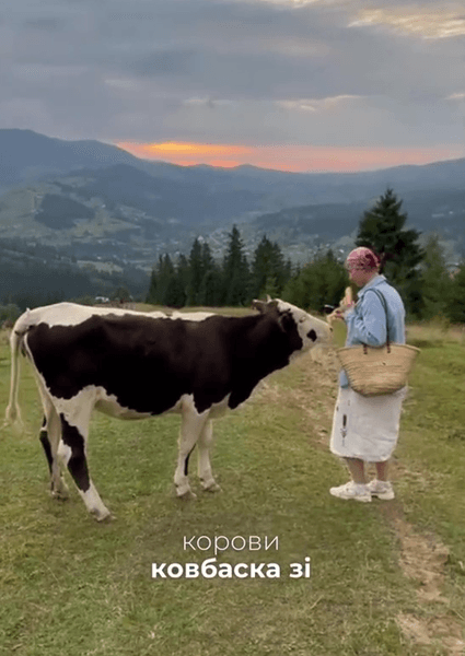 Жінка з коровою на пасовищі