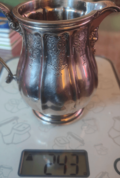 Мужчина взвесил еребряный кувшин из стерлингового серебра на кухонных весах