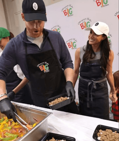 арри и Меган в фартуках готовят блюда для нуждающихся на кухне Our Big Kitchen Los Angeles