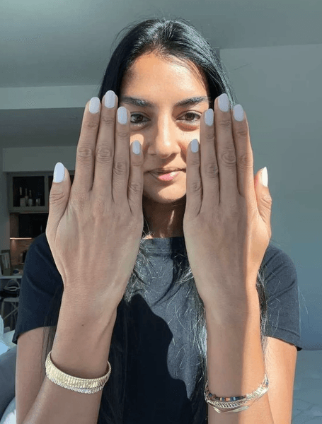 Моделът показва перфектно поддържаните си ръце преди фотосесия. Жената показва добре поддържаните си ръце с кокетно направен маникюр, подчертавайки професията на модела.