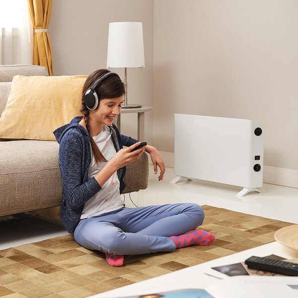 Конвекторный обогреватель DELONGHI HSX 2320 рядом с девушкой