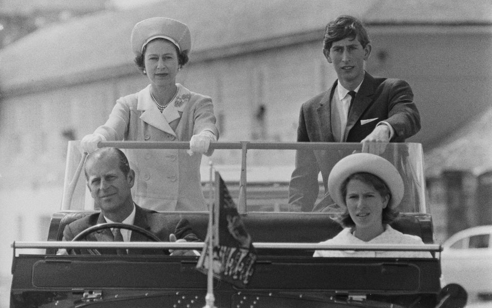 Принц Филипп управляет внедорожником Land Rover во время визита королевской семьи на острова Силли в 1967 году. Рядом с Филиппом — принцесса Анна, на втором ряду вместе с Елизаветой II — принц Чарльз