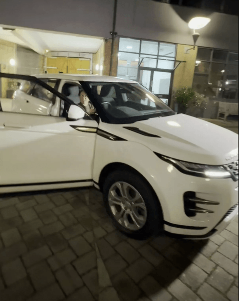 Співробітниця сидить за кермом білого Range Rover, виграного в різдвяному розіграші на роботі