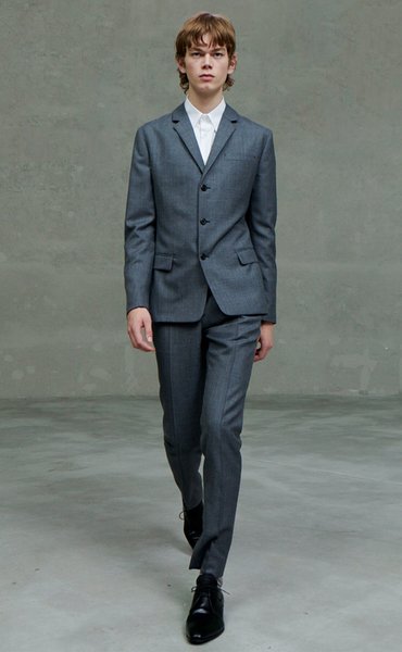 Модель на подиуме в сером костюме