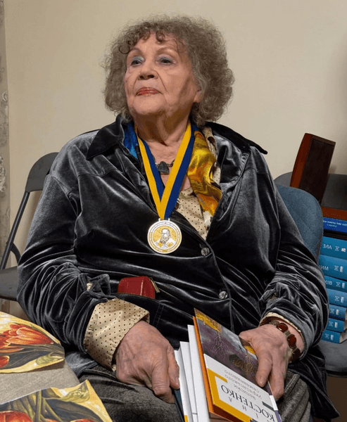 Ліна Костенко сидить на кріслі