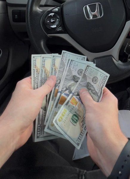 Несподівана знахідка в кишені костюма Чоловік тримає в руках купюри по 100 доларів, знайдені в кишені вживаного піджака